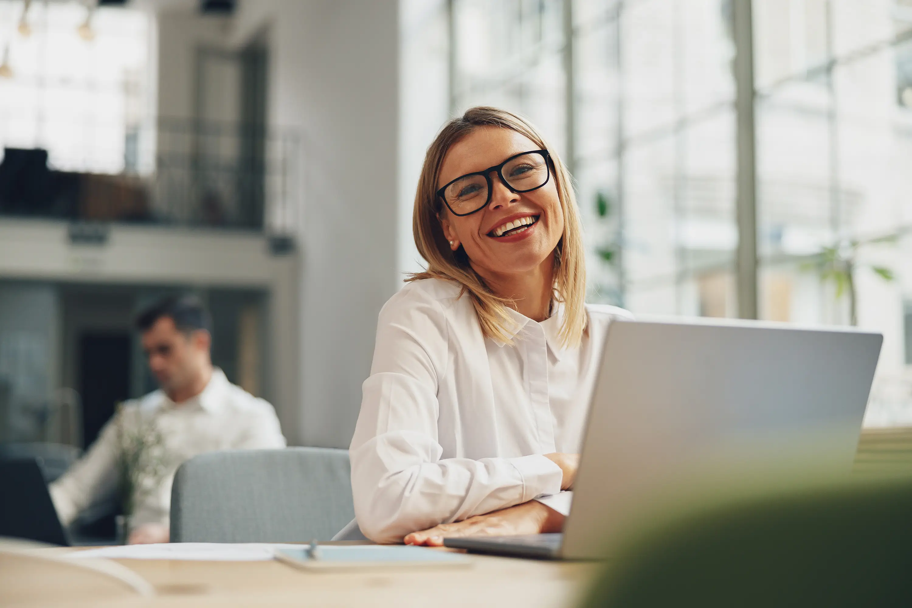 Business owner smiling while setting up a cookie consent banner on her laptop