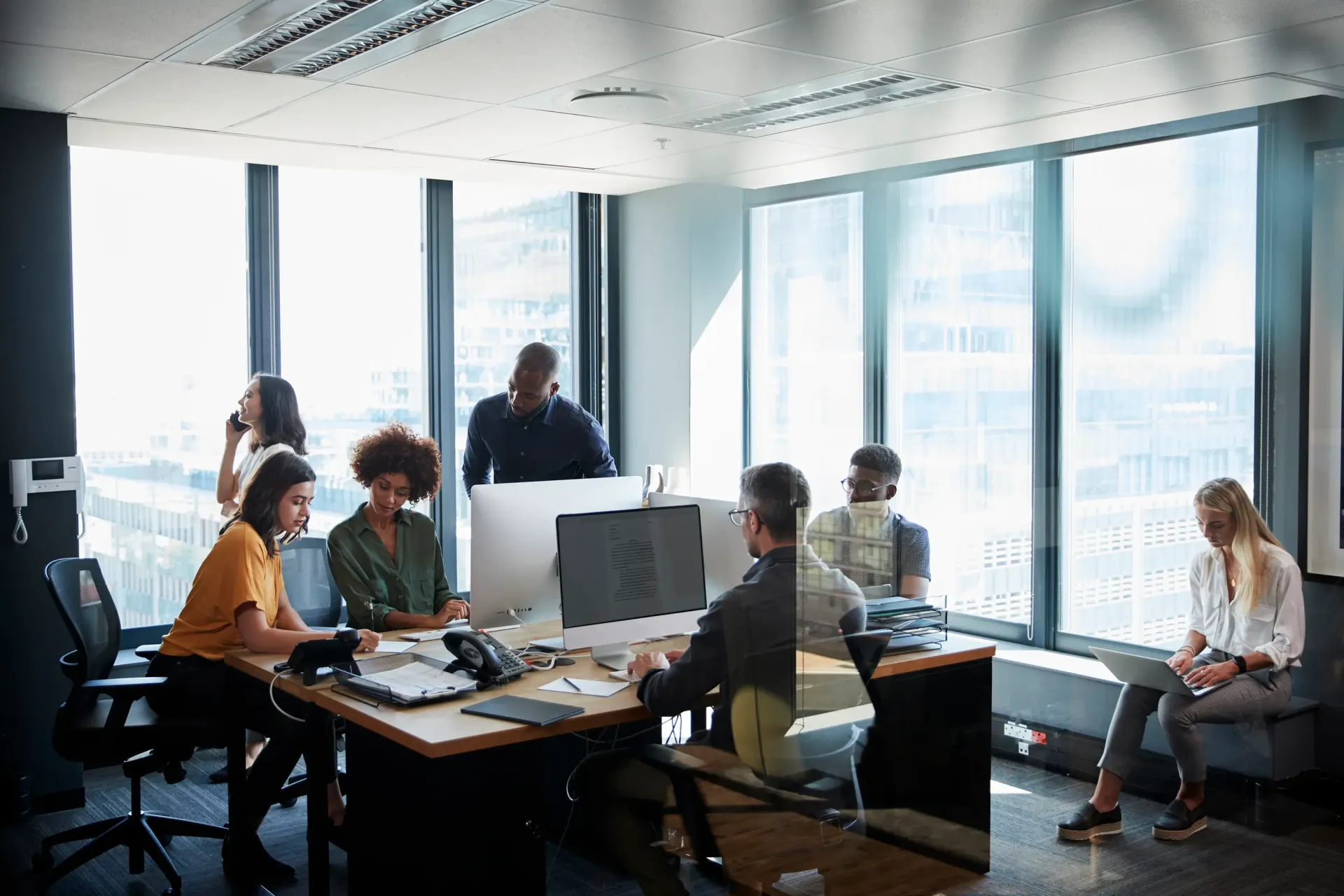 A team reviewing work together at a shared desk